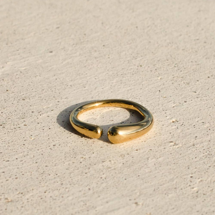 Gold ring on a beige sand-like surface