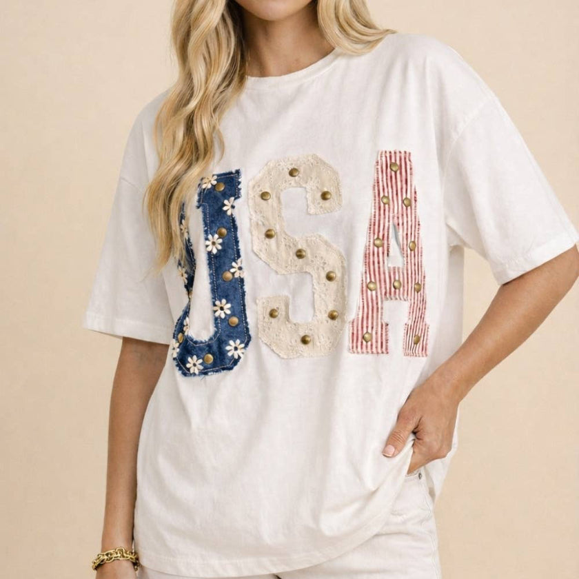 Woman wearing a white t-shirt with 'USA' design on a beige background