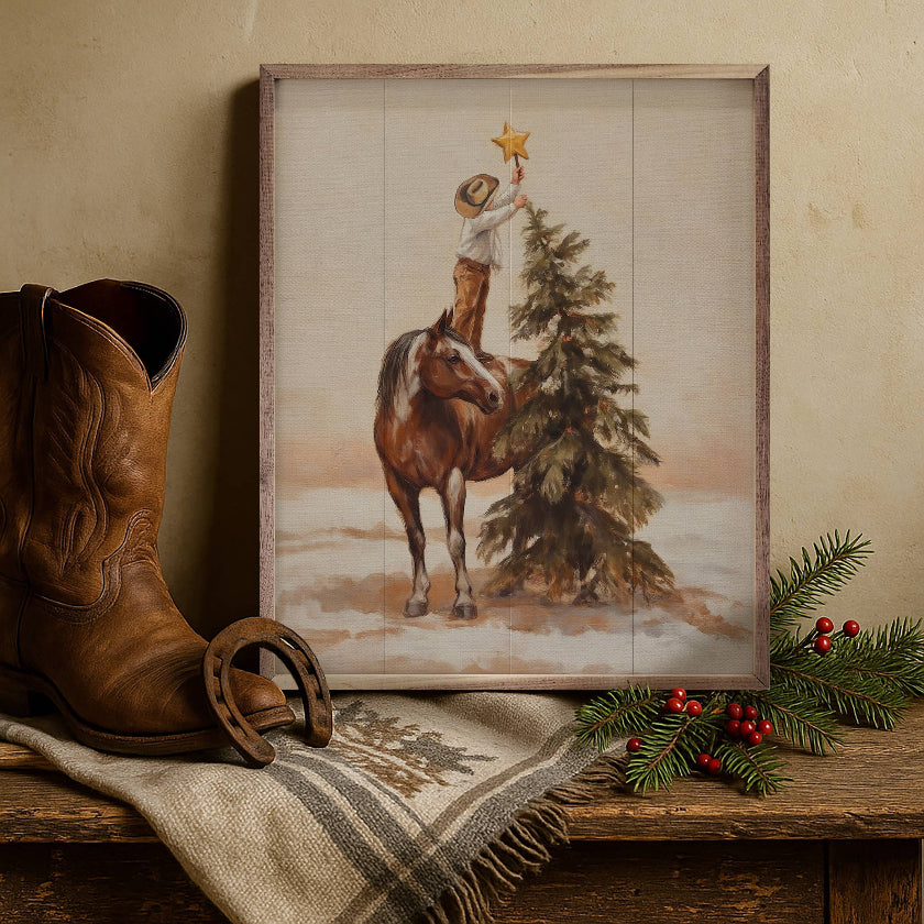 Framed artwork of a cowboy on horseback with a Christmas tree, next to a brown boot and festive decorations.