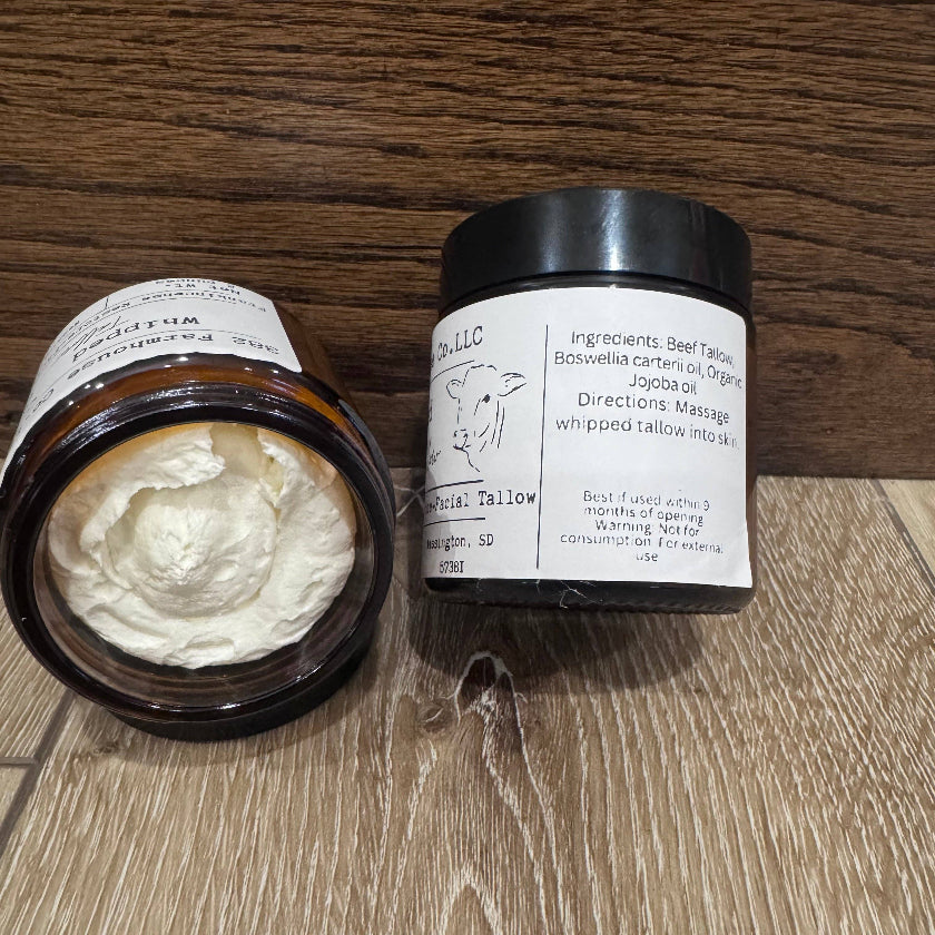 Two containers of whipped cream with labels on a wooden surface