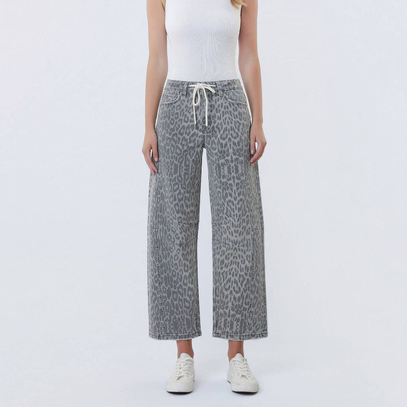 Woman wearing a white tank top and leopard print pants on a white background