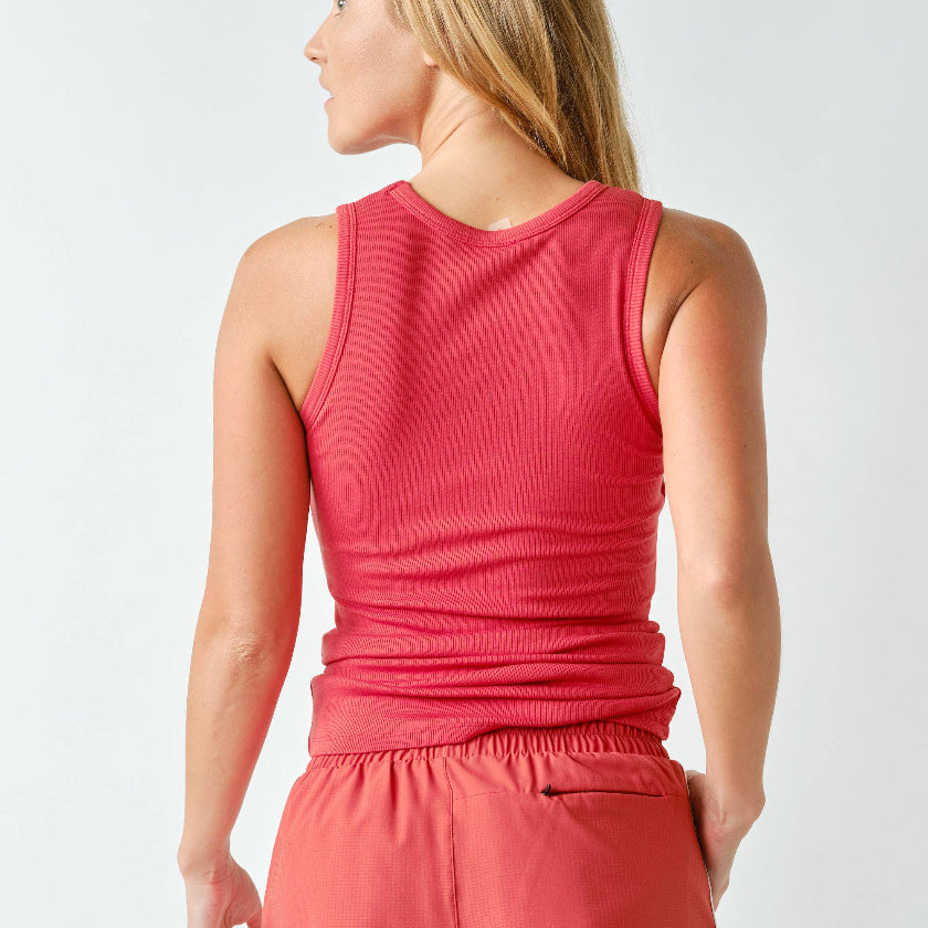 Woman wearing a red sleeveless top and shorts on a white background