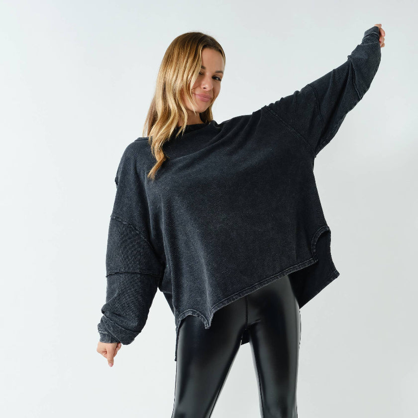 Woman wearing a dark gray oversized sweater and matching pants on a white background