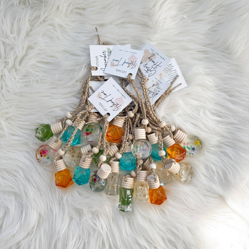 Decorative hanging with colorful glass bottles and wooden beads on a fluffy white surface