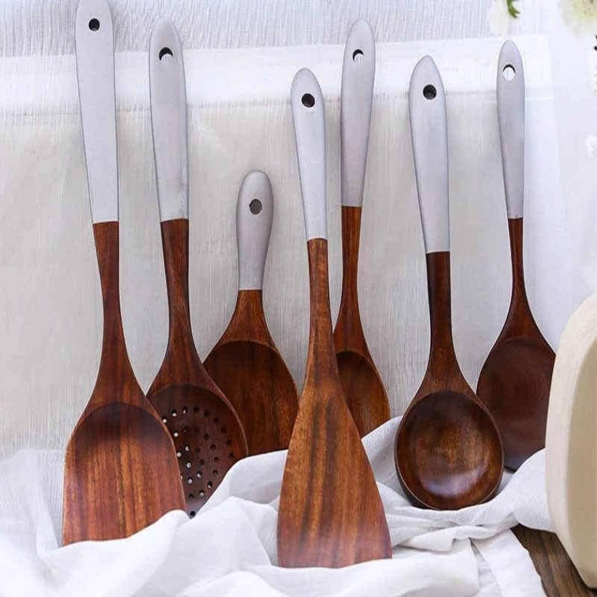 Set of wooden spoons with white handles on a white background
