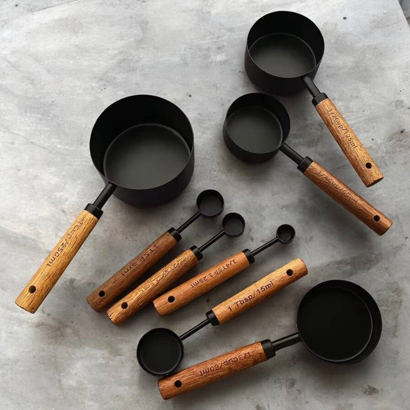 Set of measuring cups with wooden handles on a gray surface