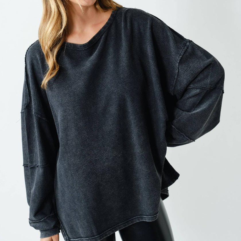 Woman wearing a dark gray oversized sweater on a white background