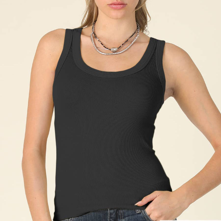 Woman wearing a black tank top against a beige background