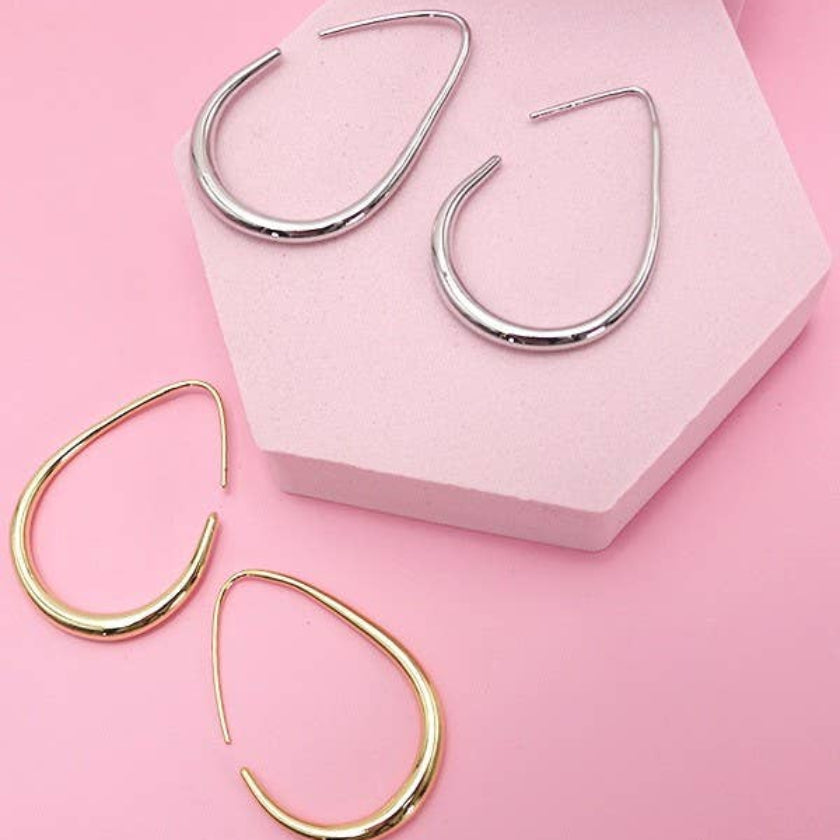 Pair of gold hoop earrings on a pink background