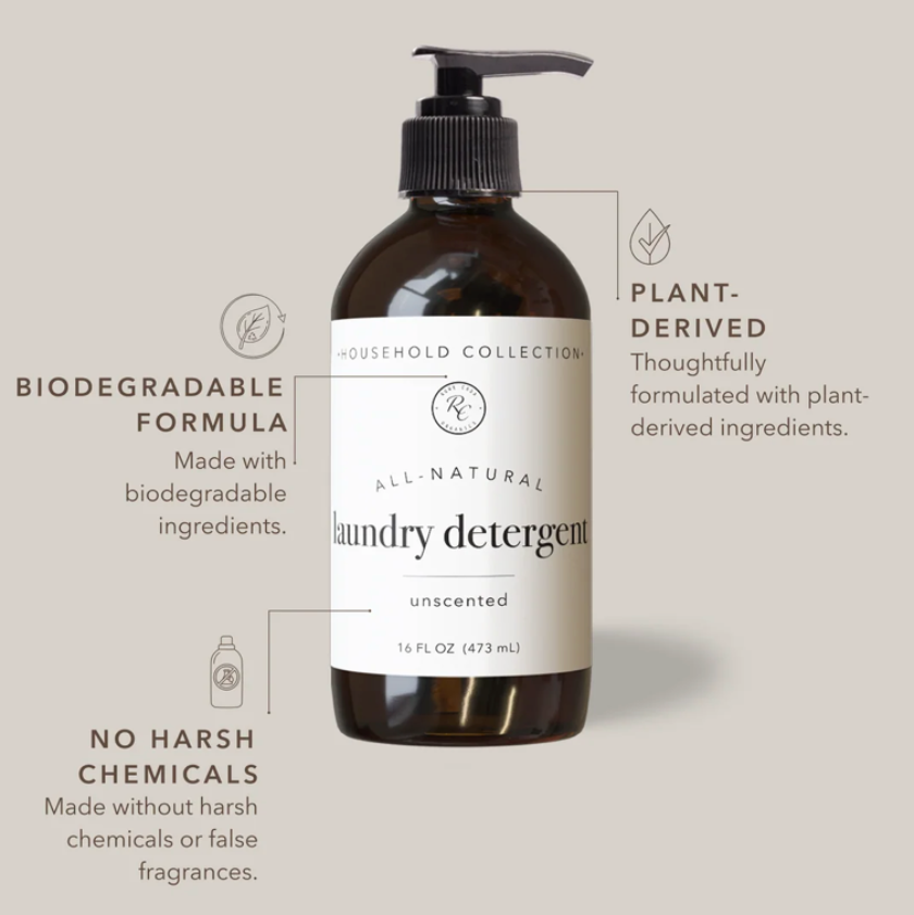 An amber glass bottle of laundry detergent with a black pump and white label, shown on a light beige background with callout text highlighting biodegradable formula, plant-derived ingredients, unscented, and no harsh chemicals.