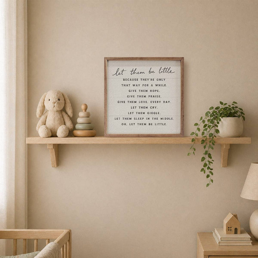 Nursery room with a shelf featuring a teddy bear, stack of books, and framed quote on a beige wall.