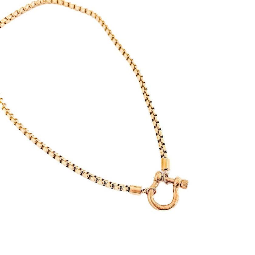 Gold chain necklace with a clasp on a white background