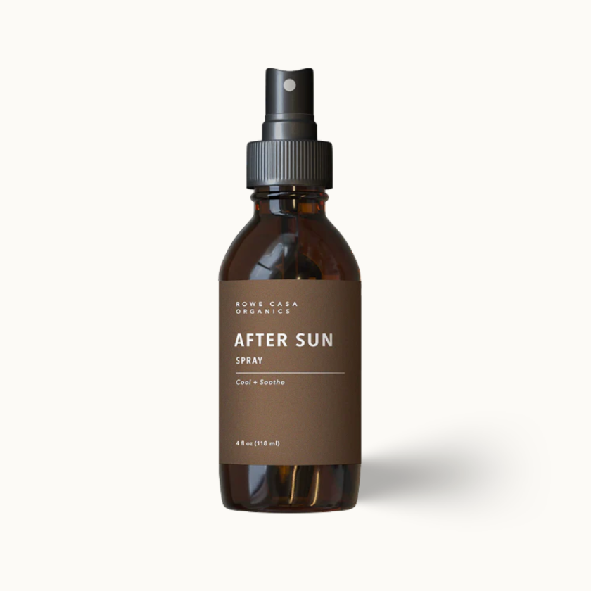A single amber glass spray bottle with a black pump dispenser and a brown label reading 'SUN-COCA ORGANICS AFTER SUN SPRAY' on a clean off-white background.