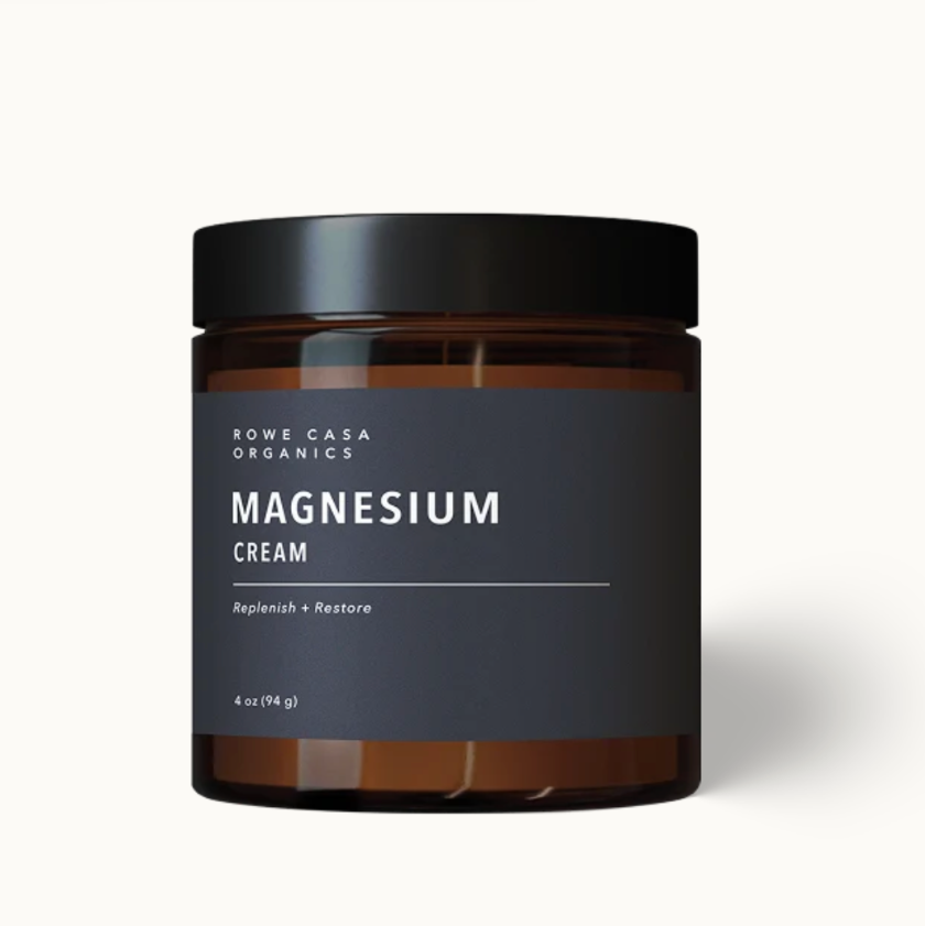 A 4 oz amber glass jar of Rowe Casa Organics Magnesium Cream with a black lid and dark gray label, set against a clean off-white background.