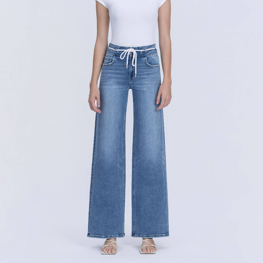 Woman wearing a white t-shirt and blue jeans on a white background