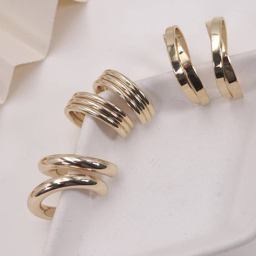 Gold spiral earrings on a white surface