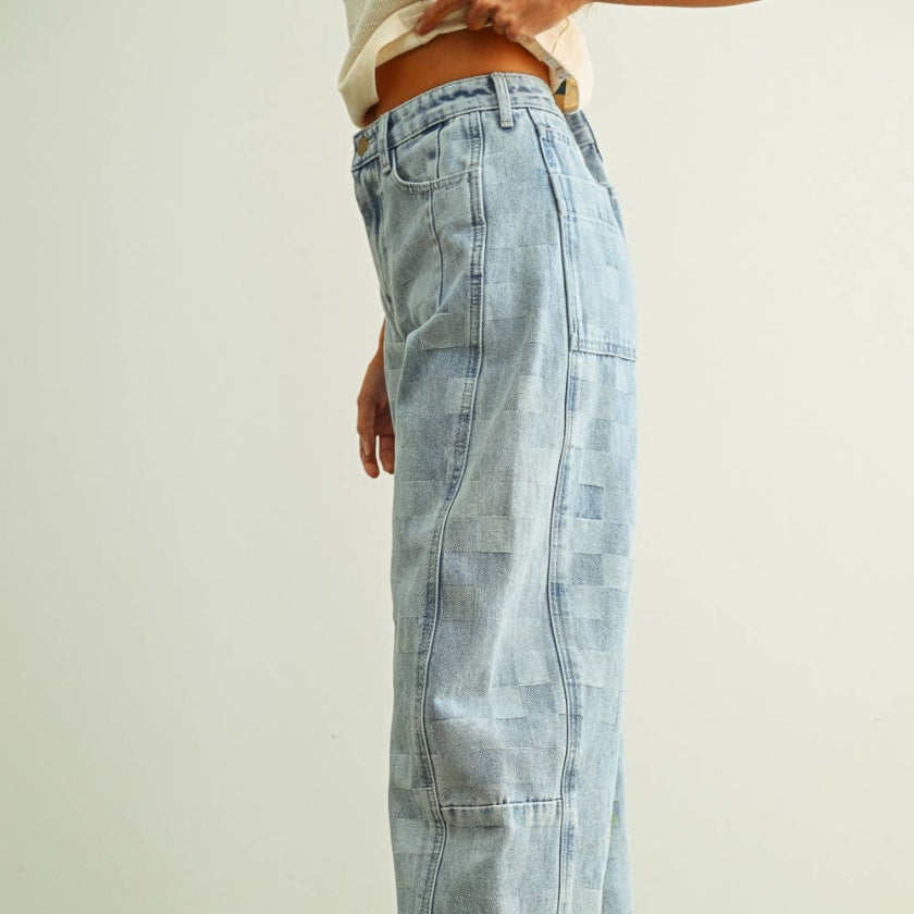 Light blue denim jeans worn by a person on a green floor with a white background