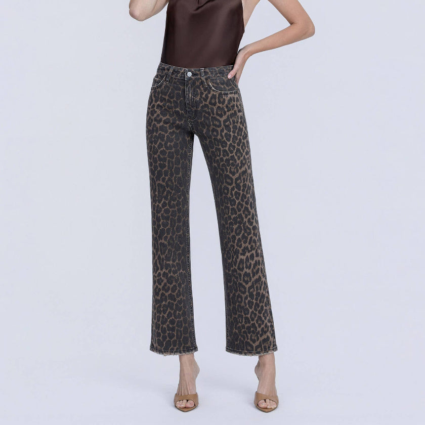 Woman wearing a brown top and leopard print pants on a white background