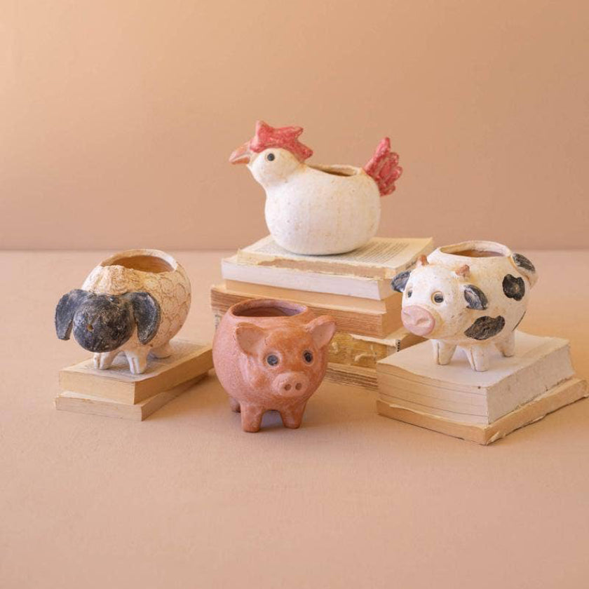Set of animal-shaped ceramic planters on a beige background