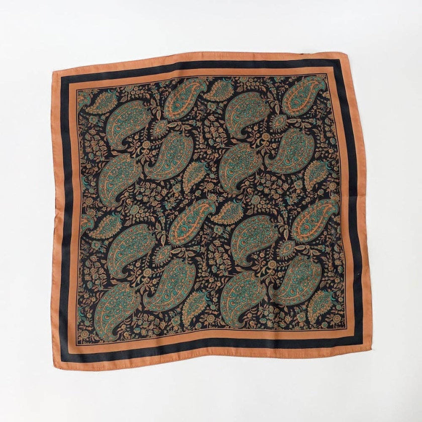A square silk scarf featuring an intricate paisley and floral pattern in teal, gold, and black, finished with a solid orange border, laid flat on a white background.